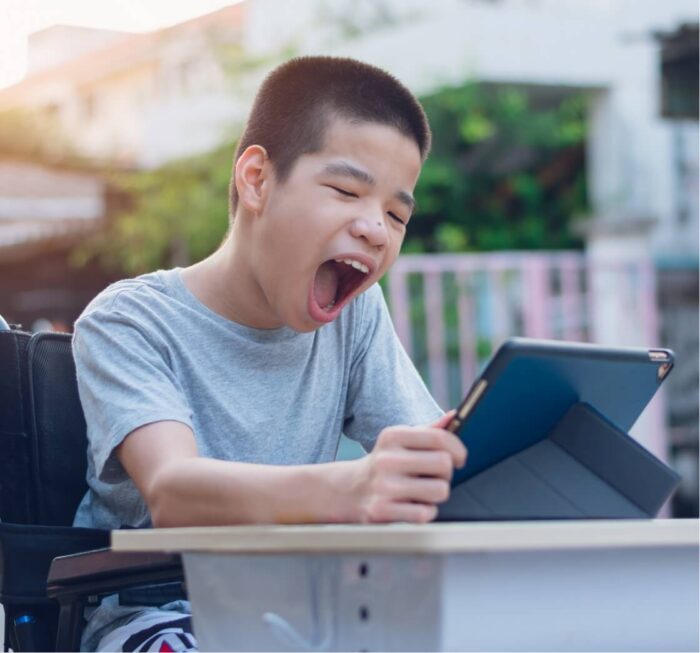 young boy holding tablet making a facial expression