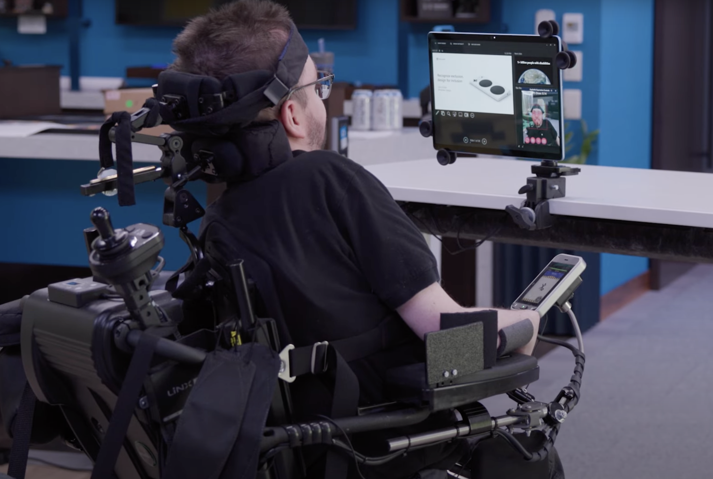 A man sitting in a powerchair controls his computer using Cephable Controls