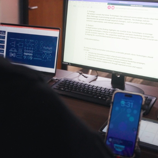 A user working on a dual-monitor setup with assistive technology, leveraging Cephable’s voice controls on a connected Cephable companion app smartphone for hands-free navigation